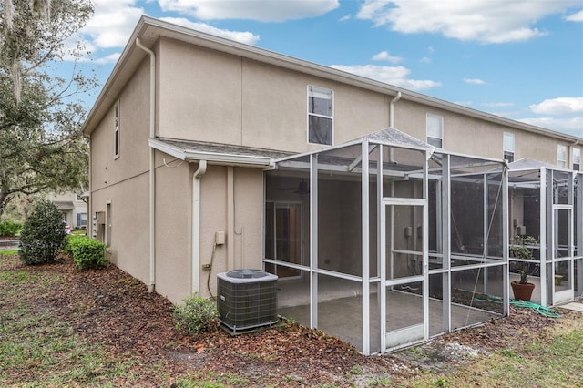 rear view of house featuring cooling unit, a patio area, and stucco siding