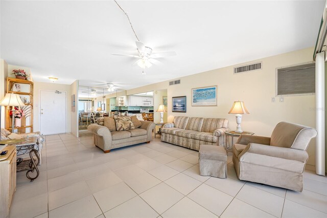 living room featuring a ceiling fan, visible vents, and light tile patterned flooring