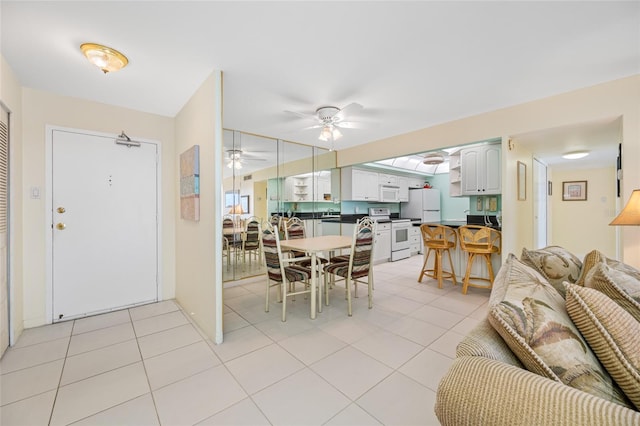 dining room with light tile patterned floors and a ceiling fan