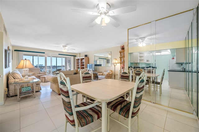 dining area with light tile patterned flooring and a ceiling fan