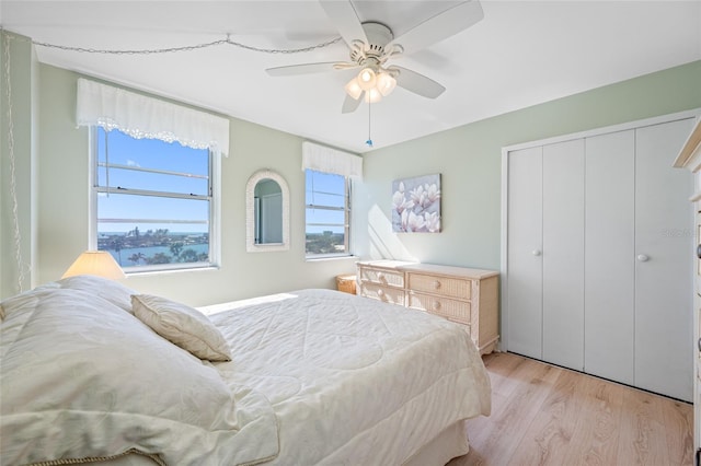 bedroom with a ceiling fan, a closet, and light wood finished floors