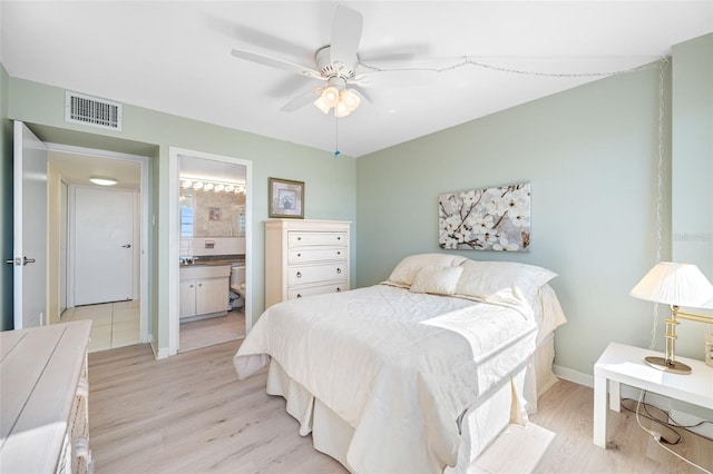 bedroom with visible vents, light wood-style floors, ceiling fan, ensuite bath, and baseboards