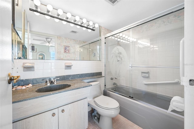 bathroom with shower / bath combination with glass door, tile walls, visible vents, toilet, and vanity