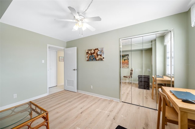 bedroom with baseboards, visible vents, a ceiling fan, light wood-style flooring, and a closet