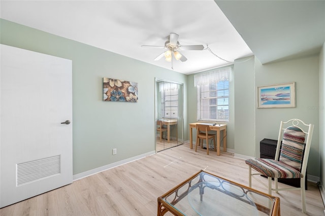 sitting room featuring wood finished floors, a ceiling fan, and baseboards