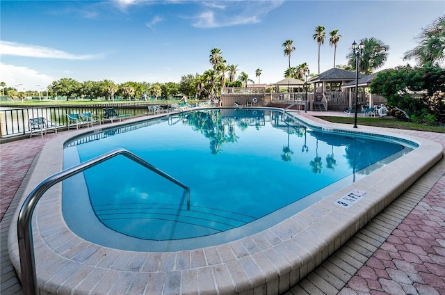 community pool with fence and a gazebo