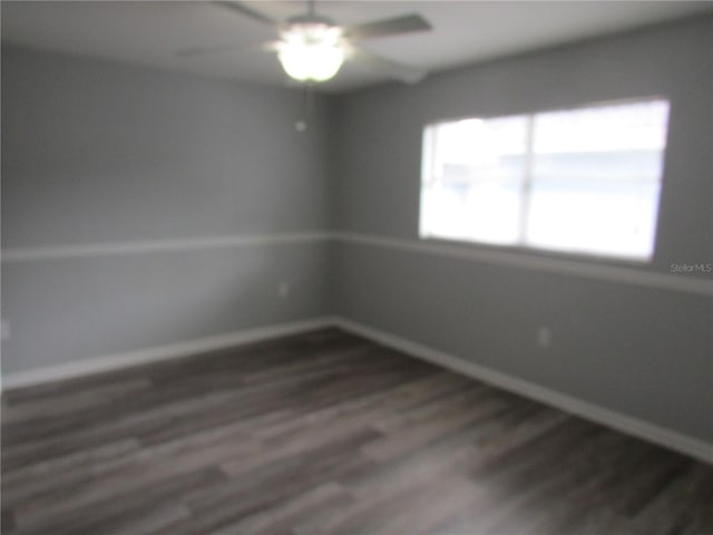 spare room featuring dark wood finished floors and baseboards