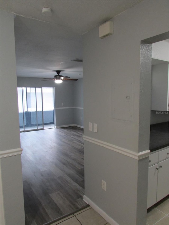 empty room featuring light wood-type flooring, ceiling fan, and baseboards