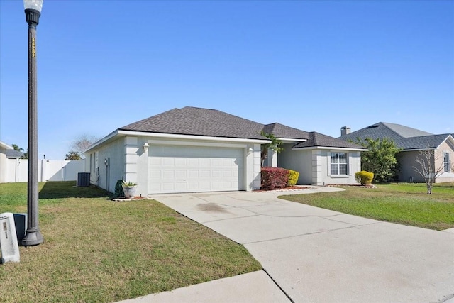 ranch-style home featuring stucco siding, concrete driveway, an attached garage, fence, and a front lawn