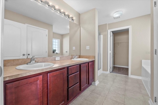 bathroom featuring tile patterned flooring, a garden tub, a sink, and double vanity