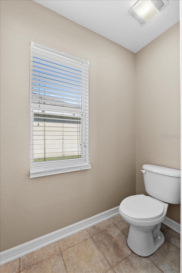 bathroom with toilet, baseboards, visible vents, and tile patterned flooring