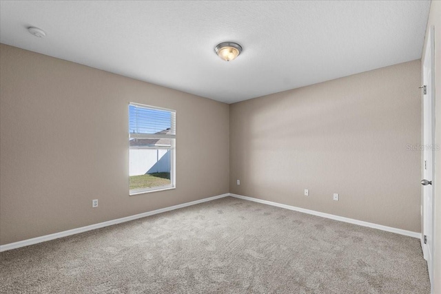 carpeted spare room with baseboards