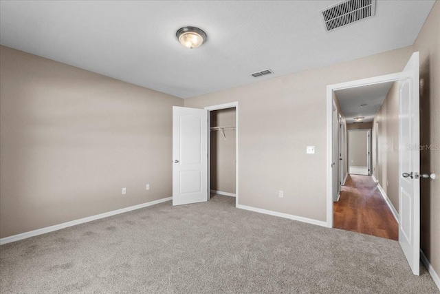 unfurnished bedroom featuring a closet, carpet, visible vents, and baseboards