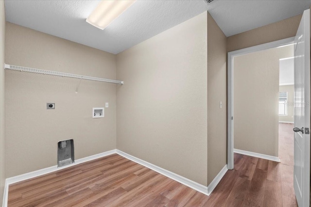 clothes washing area featuring hookup for a washing machine, hookup for an electric dryer, laundry area, baseboards, and light wood-style floors