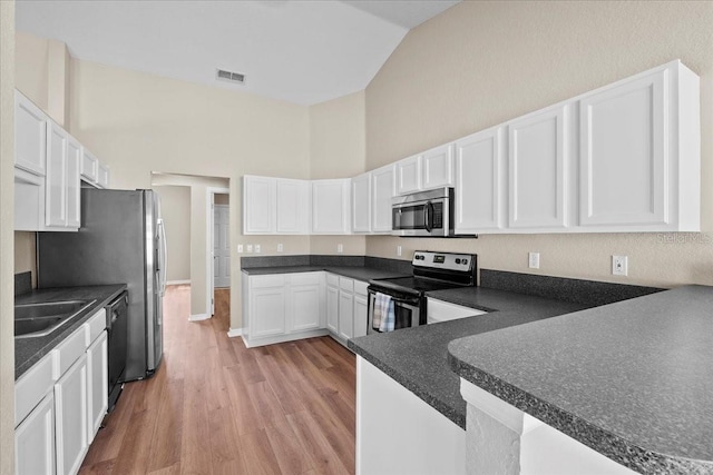 kitchen featuring appliances with stainless steel finishes, white cabinetry, a sink, and light wood-style flooring