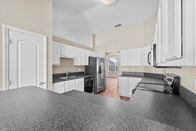 kitchen featuring dark countertops, visible vents, stainless steel appliances, and a sink