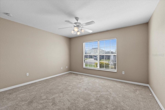 spare room featuring carpet, baseboards, ceiling fan, and a textured ceiling