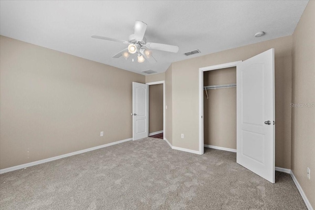 unfurnished bedroom with a closet, carpet, visible vents, and baseboards