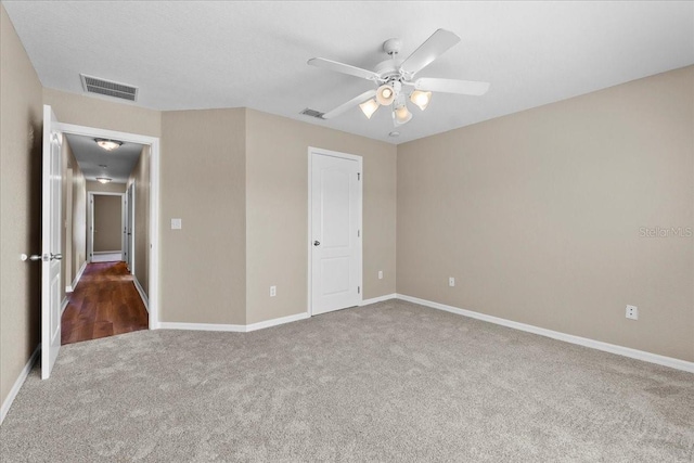 unfurnished bedroom featuring carpet floors, visible vents, baseboards, and a ceiling fan