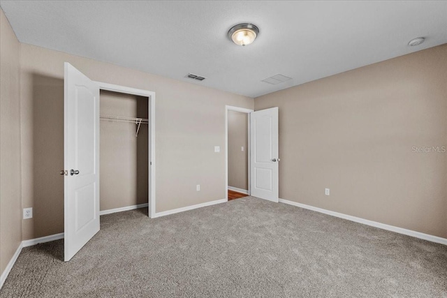 unfurnished bedroom with carpet, a closet, visible vents, and baseboards