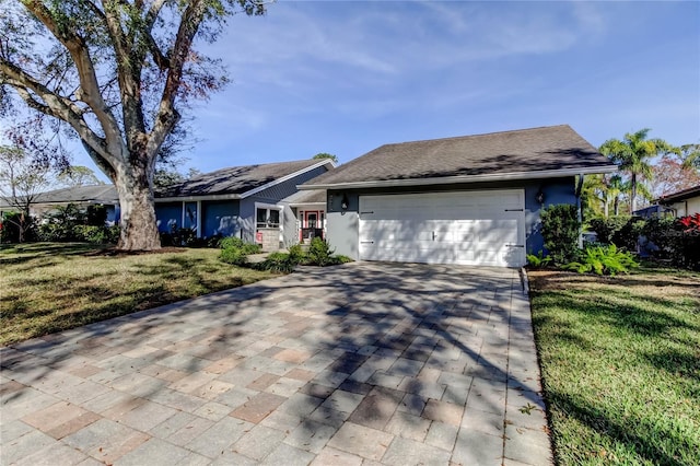 ranch-style home featuring a garage, a front yard, decorative driveway, and stucco siding