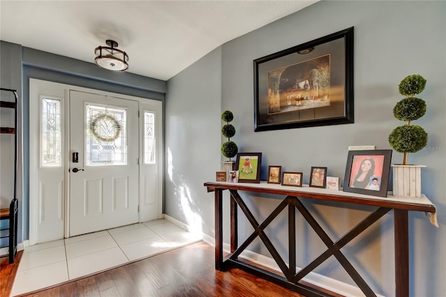 foyer with light wood-style flooring and baseboards