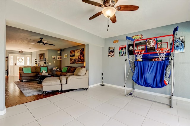 living area with ceiling fan, tile patterned floors, and baseboards