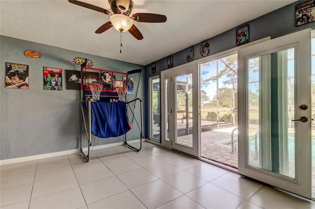 doorway to outside featuring ceiling fan, tile patterned flooring, and baseboards