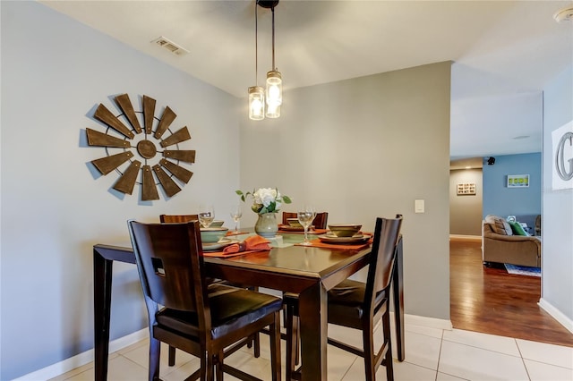 dining area featuring light tile patterned floors, visible vents, and baseboards