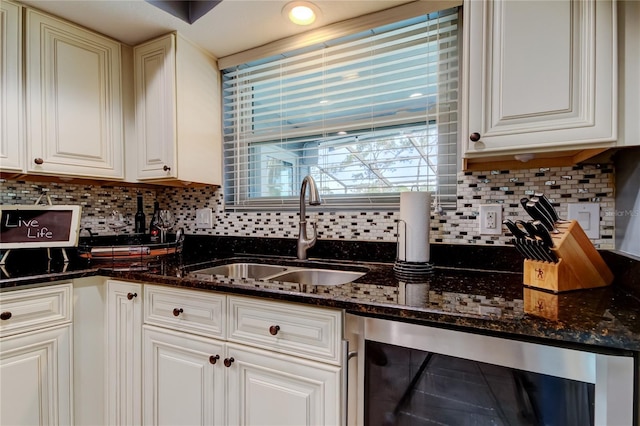 kitchen with wine cooler, white cabinetry, a sink, and decorative backsplash