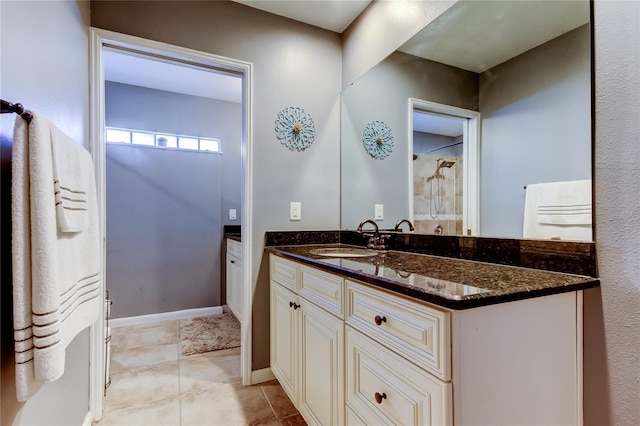 full bath featuring vanity, baseboards, and tile patterned floors