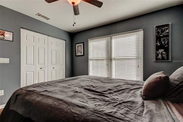 bedroom featuring ceiling fan, visible vents, and a closet