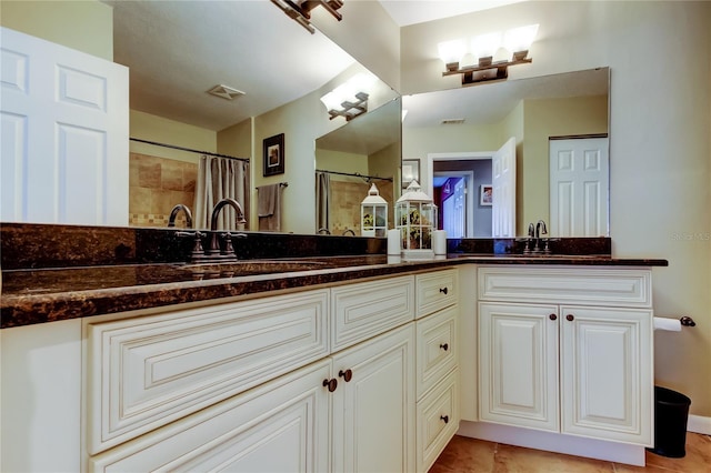 bathroom with double vanity, a sink, and visible vents