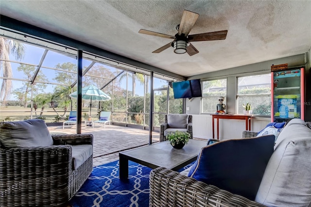 interior space featuring a ceiling fan, brick floor, and a textured ceiling