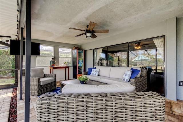 sunroom / solarium featuring ceiling fan