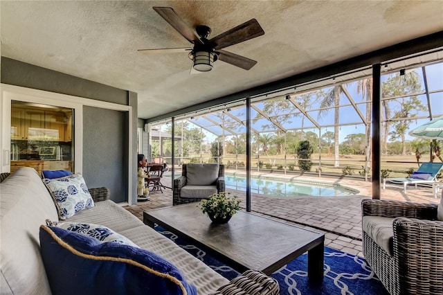 sunroom / solarium featuring a ceiling fan