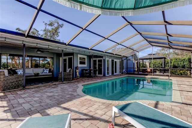 outdoor pool with glass enclosure, a patio, and outdoor lounge area