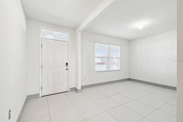 foyer entrance with light tile patterned flooring and baseboards