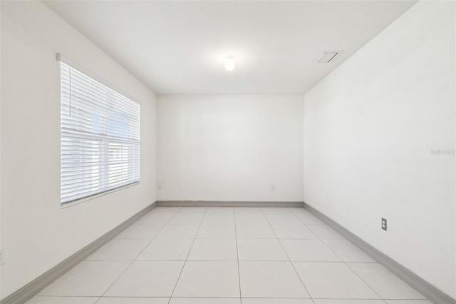 unfurnished room with visible vents, baseboards, and light tile patterned flooring