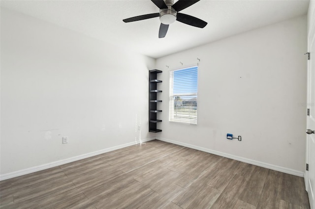 spare room with ceiling fan, wood finished floors, and baseboards