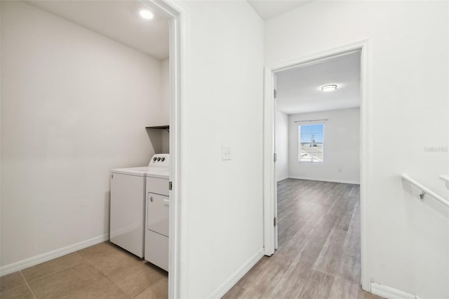 laundry area with baseboards, laundry area, light wood-type flooring, and washer and dryer