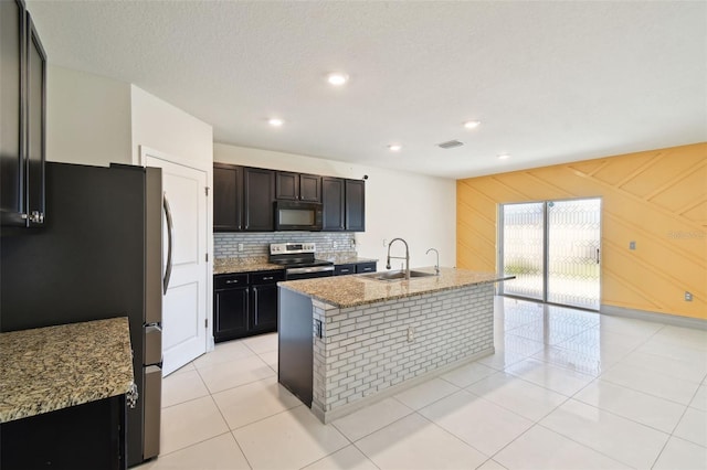 kitchen featuring stainless steel appliances, light stone counters, a sink, and visible vents