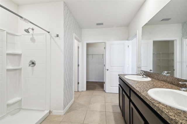 full bath featuring tile patterned flooring, visible vents, a sink, and a shower stall