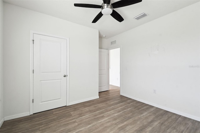 unfurnished bedroom featuring baseboards, visible vents, and wood finished floors