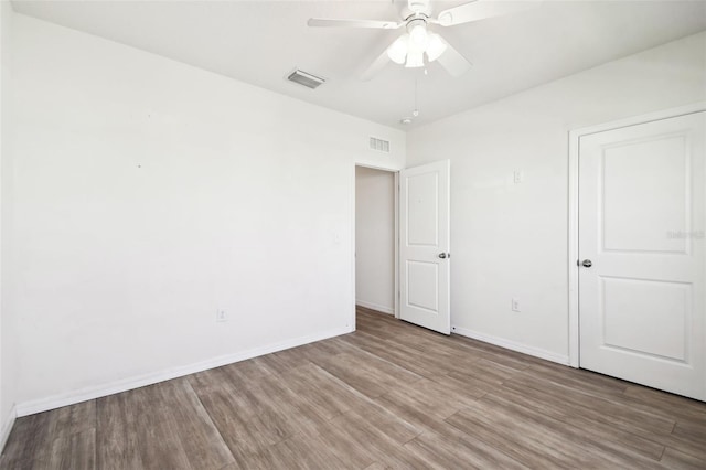 unfurnished bedroom with baseboards, visible vents, and wood finished floors