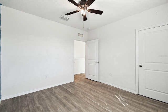 unfurnished bedroom with ceiling fan, wood finished floors, visible vents, and baseboards