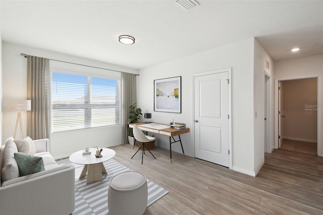 sitting room featuring light wood-style floors, baseboards, visible vents, and recessed lighting