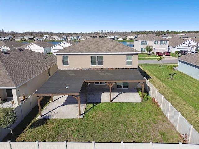 rear view of property with a lawn, a patio area, a fenced backyard, and a residential view