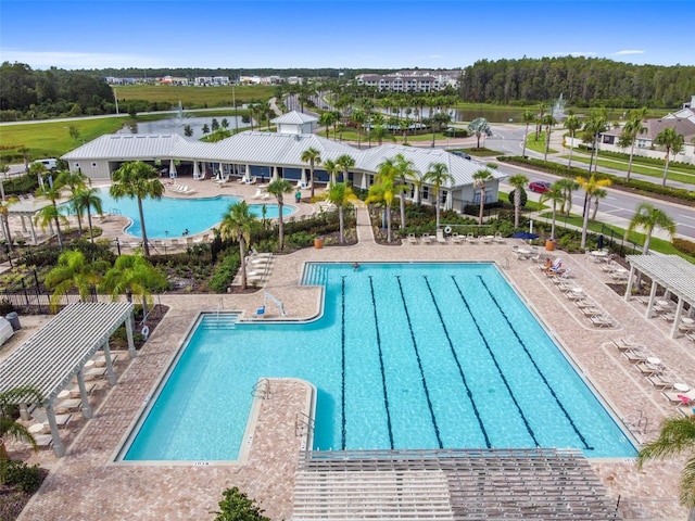 community pool with fence and a patio