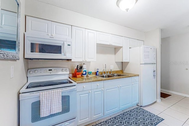 kitchen featuring light countertops, white cabinets, a sink, white appliances, and baseboards